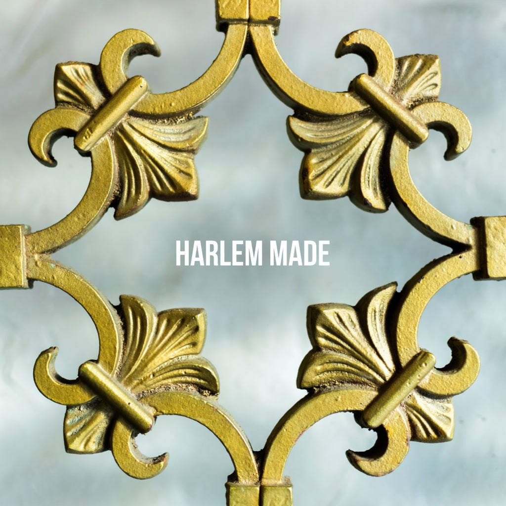 Image displaying a gold ornamental gate with the words “Harlem Made” centered and bracketed in white